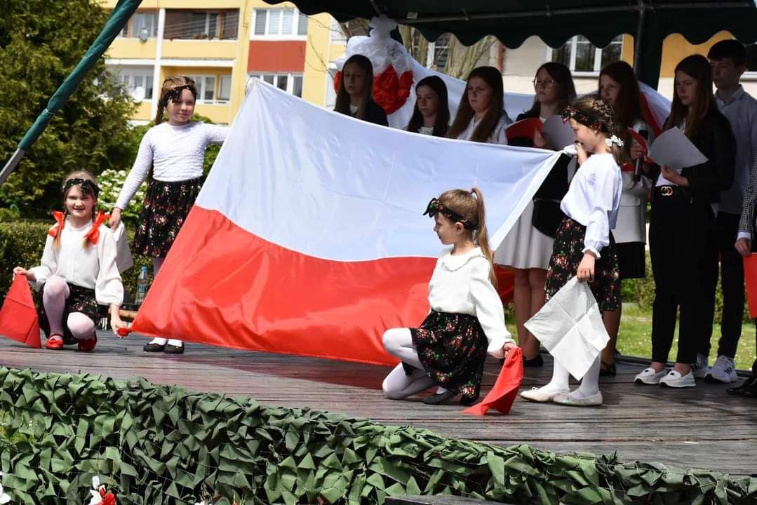 zdjęcie przedstawia dzieci z flagą Polski